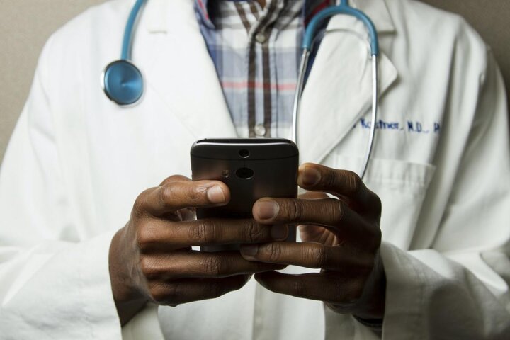 Doctor with lab coat and smartphone